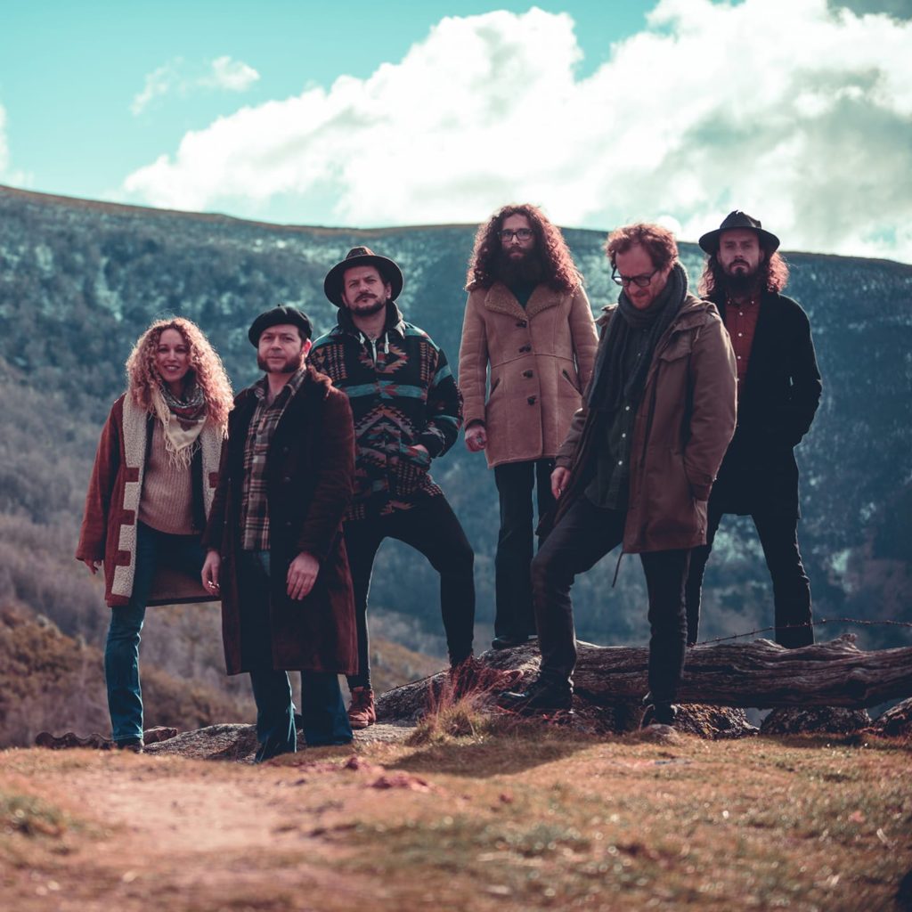 Os membros do grupo de folk-rock psicodélico Moura, pousando á cámara nun lugar montañoso