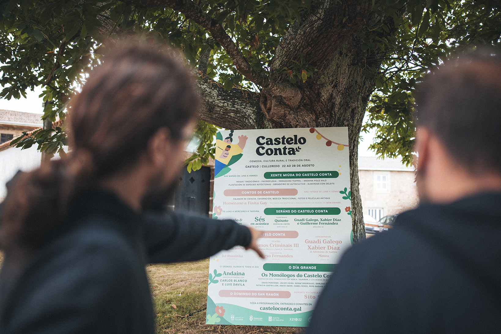 O cartel do festival Castelo Conta 2022, apoiado nunha árbore, durante a presentación do evento